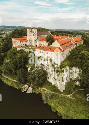 Vue aérienne de l'abbaye bénédictine des Saints Pierre et Paul à Tyniec, Pologne. Ancienne architecture du monastère catholique avec des tours et des toits rouges, la religion et l'histoire point de repère sur les rochers au-dessus de l'eau Banque D'Images