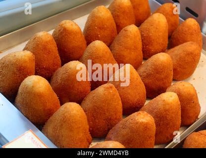 De nombreux aliments frits appelés arancini ora arancine en langue italienne remplis de viande de légumes de riz ou de fromage en vente sur un étal de marché en Sicile southe Banque D'Images