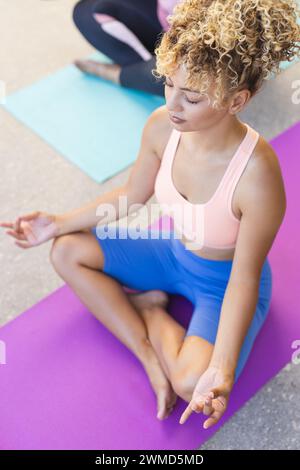 Jeune femme biraciale pratique le yoga à la maison, avec espace de copie Banque D'Images
