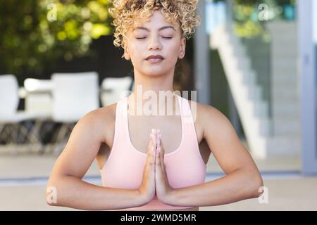 Une jeune femme biraciale pratique le yoga en plein air Banque D'Images