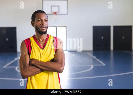 Homme afro-américain se tient confiant sur un terrain de basket-ball Banque D'Images