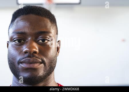 Un jeune homme afro-américain se tient confiant dans une salle de gym, avec un espace de copie Banque D'Images