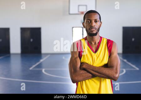 Homme afro-américain se tient confiant sur un terrain de basket-ball Banque D'Images