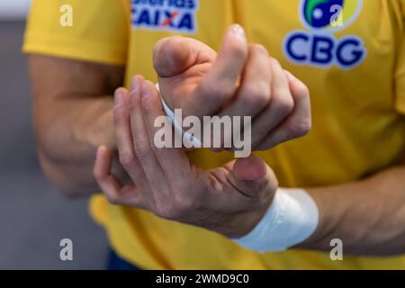 Cottbus, Allemagne. 25 février 2024. Gymnastique : Coupe du monde, finale dans la Lausitz Arena. Un gymnaste prépare ses poignets avec un ruban médical. Crédit : Frank Hammerschmidt/dpa/Alamy Live News Banque D'Images