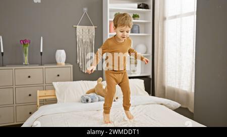 Un jeune garçon joyeux saute sur un lit dans une chambre moderne confortable, incarnant l'innocence de l'enfance. Banque D'Images