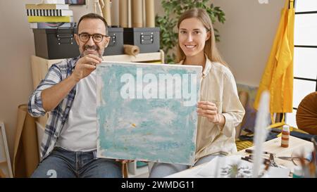 Deux artistes heureux, souriant avec confiance, partageant un moment de créativité, montrant leur talent de dessinateur dans une classe de studio d'art ensemble Banque D'Images