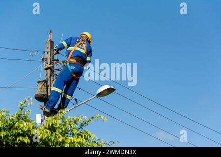 Aratuipe, Bahia, Brésil - 30 mai 2015 : technicien sur un poteau électrique en réparation. Quartier Maragogipinho de la ville d'Aratuipe en B. Banque D'Images