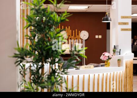 Entrée de l'hôtel, élégant comptoir de réception moderne avec réception avec rangée d'horloges avec différents fuseaux horaires accrochés au mur, personne. Concept de design d'intérieur d'hospitalité Banque D'Images