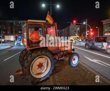 25 février 2024, Brandebourg, Francfort (Oder) : un agriculteur bloque la route d'accès au poste frontalier germano-polonais de Stadtbrücke à Francfort (Oder) avec son tracteur pendant la nuit. En réponse aux plans d'austérité du gouvernement allemand, les agriculteurs, les commerçants et les artisans ont une fois de plus appelé à protester. Photo : Patrick Pleul/dpa Banque D'Images