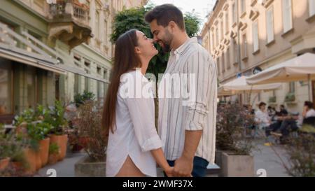 Heureux couple européen caucasien rue de la ville tenant des mains embrassant ensemble homme femme amoureux lune de miel date de famille souriant à l'extérieur du mariage Banque D'Images
