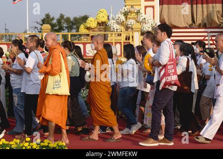 Lors des célébrations pour Makha Bucha (festival bouddhiste) à Bangkok, en Thaïlande, des moines bouddhistes et des laïcs contournent un sanctuaire bouddhiste Banque D'Images