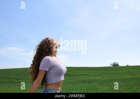 Profil d'une femme occasionnelle respirant l'air frais dans un large champ Banque D'Images