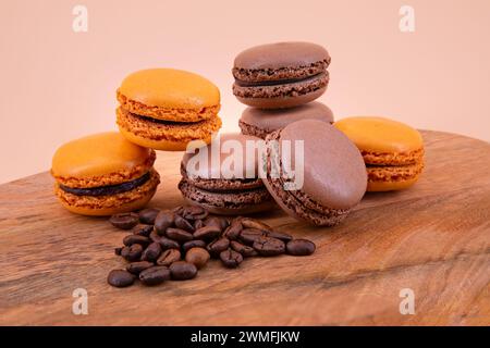 Macarons français marron et orange sur une planche de bois Banque D'Images