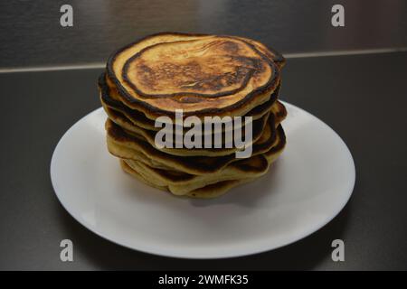 Un petit déjeuner copieux, des plats maison délicieusement préparés, beaucoup de grandes crêpes moelleuses sont disposés sur une grande assiette blanche. Banque D'Images