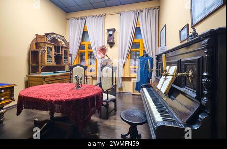 Une recréation d'une époque tsariste, riche, salle de séjour de fantaisie avec piano. Au Musée d'histoire locale d'Almaty, au Kazakhstan. Banque D'Images