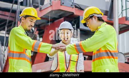 Les dockers se tiennent les mains ensemble dans le terminal à conteneurs. Logistique, travail d'équipe Banque D'Images