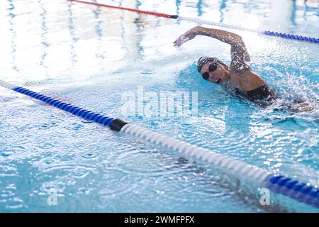 Une athlète nageuse caucasienne nage dans une piscine intérieure Banque D'Images