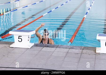 La nageuse athlète caucasienne célèbre la victoire dans une compétition de natation Banque D'Images