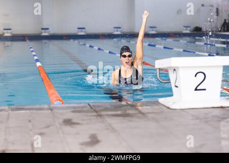 La nageuse athlète caucasienne célèbre une victoire en natation à la piscine Banque D'Images