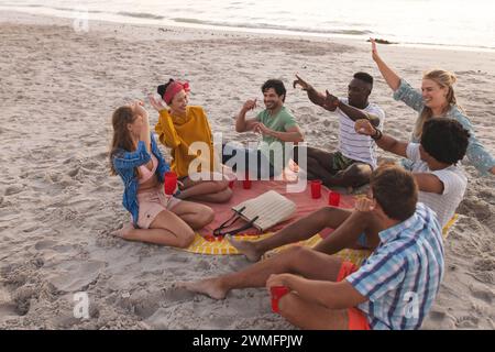 Un groupe diversifié d'amis apprécient une réunion sur la plage Banque D'Images