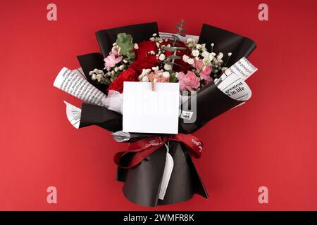 Carte de voeux vierge et bouquet de roses rouges sur fond rouge Banque D'Images