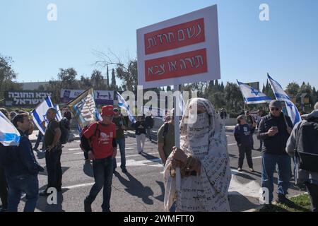 Jérusalem, Israël. 26 février 2024. Les manifestants se rassemblent devant la Cour suprême d'Israël alors que les juges entendent des appels contestant les réformes proposées par Netanyahou en matière de service militaire. Le projet de loi vise à étendre le service obligatoire pour les hommes et les réservistes, tandis que les manifestants exigent un partage égal du fardeau et la fin des exemptions pour les communautés ultra orthodoxes, appelant à ce que tout le monde passe sous le brancard. Crédit : NIR Alon/Alamy Live News Banque D'Images