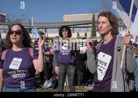 Jérusalem, Israël. 26 février 2024. Les manifestants se rassemblent devant la Cour suprême d'Israël alors que les juges entendent des appels contestant les réformes proposées par Netanyahou en matière de service militaire. Le projet de loi vise à étendre le service obligatoire pour les hommes et les réservistes, tandis que les manifestants exigent un partage égal du fardeau et la fin des exemptions pour les communautés ultra orthodoxes, appelant à ce que tout le monde passe sous le brancard. Crédit : NIR Alon/Alamy Live News Banque D'Images