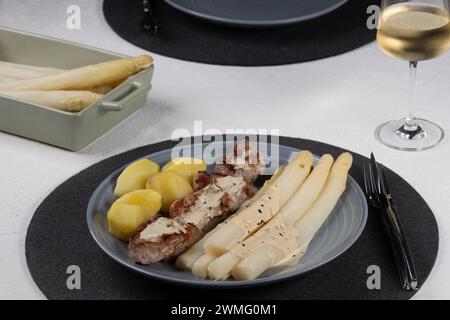 Filet de porc avec asperges et moutarde - sauce estragon, asperges blanches, pommes de terre, vin blanc Banque D'Images