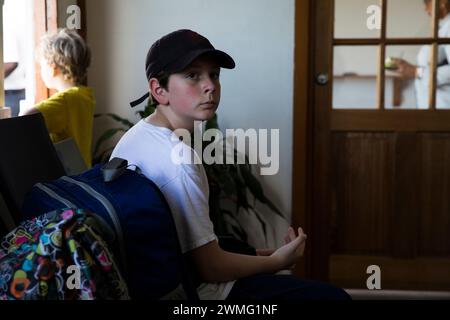 Tween Boy in Black Hat attend patiemment le ferry dans les Caraïbes Banque D'Images