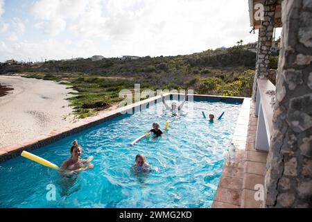 Grande famille heureuse dans la piscine à débordement sur les vacances dans les Caraïbes Banque D'Images