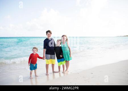 Quatre jeunes frères et sœurs postent ensemble sur Caribbean Beach Banque D'Images