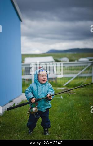 Garçon jouant avec une canne à pêche Banque D'Images