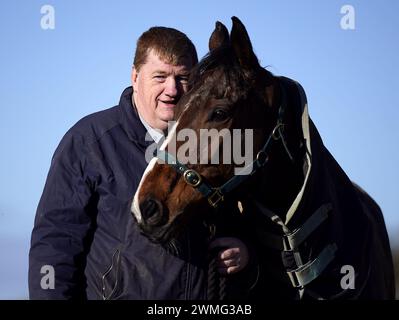 Photo du dossier datée du 12-02-2024 de l'entraîneur John 'Shark' Hanlon avec le cheval Hewick. Shark Hanlon devrait prendre une décision plus tard cette semaine sur qui sera partenaire de sa star stable Hewick dans la Boodles Cheltenham Gold Cup. Date d'émission : lundi 26 février 2024. Banque D'Images