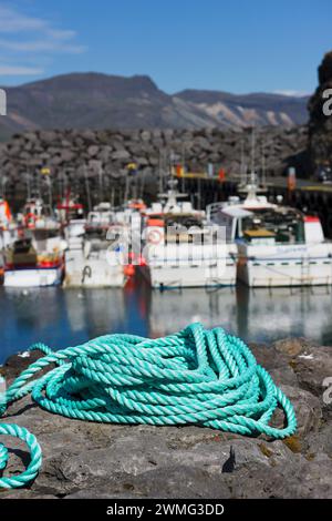 Une corde sur un rocher à côté de bateaux Banque D'Images