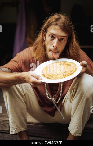 Un homme mange de fines crêpes. Portrait. Banque D'Images