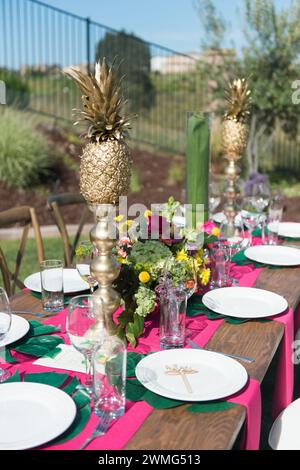 Table à thème tropical avec ananas dorés et fleurs Banque D'Images