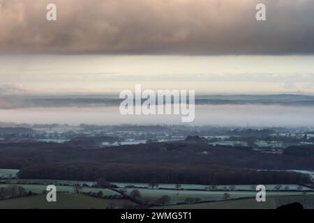 Brighton, le 25 février 2024 : brume basse sur le Weald du Sussex, vue de Devil's Dyke, dans le parc national de South Downs au lever du soleil ce matin Banque D'Images