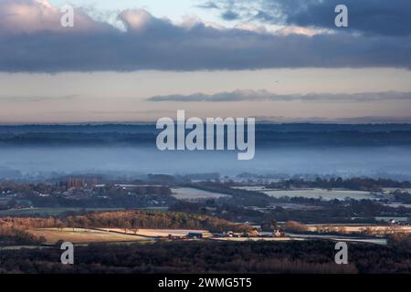 Brighton, le 25 février 2024 : brume basse sur le Weald du Sussex, vue de Devil's Dyke, dans le parc national de South Downs au lever du soleil ce matin Banque D'Images