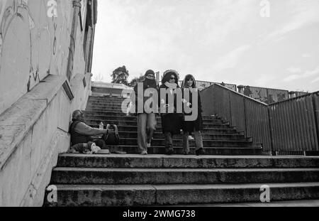 Mendiant avec chien demande l'aumône de trois femmes, la photographie a été prise le 11/18/2023 dans le centre de la ville de Parme en Italie Banque D'Images