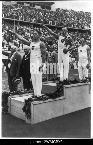 Berlin 1936, deux athlètes aux armes faisant le salut nazi lors de la cérémonie de remise des médailles aux Jeux Olympiques de Berlin. Banque D'Images