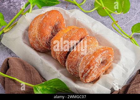 Les gourmandises : beignets dans une boîte parafine sur marbre foncé Banque D'Images