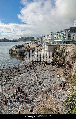 Les paddle-boarders profitent du soleil de fin février sur une plage de galets à West Hoe à Plymouth. La plage récemment mis à l'abri d'une falaise dangereuse est libre un Banque D'Images