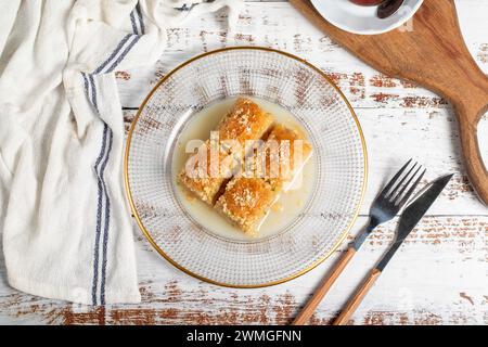 Baklava avec du lait. Baklava au lait avec noisettes sur fond blanc. Nom local sütlü nuriye baklava. Vue de dessus Banque D'Images