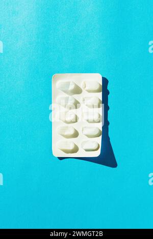 Emballage de blister de médicament vide isolé sur fond bleu. Directement au-dessus du tir. Banque D'Images