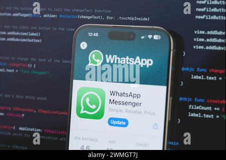 New York, États-Unis - 23 février 2024 : WhatsApp sur l'écran de l'iphone en arrière-plan de programmation de code flou Banque D'Images