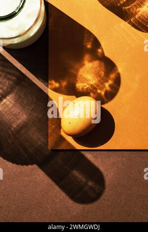 Oeuf et bouteille de lait sous lumière directe avec de longues ombres sur fond brun. Directement au-dessus de la vue de dessus. Banque D'Images