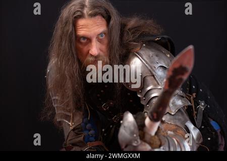 Portrait d'un homme charismatique habillé en chevalier médiéval avec une lance lors d'une reconstitution historique. Banque D'Images