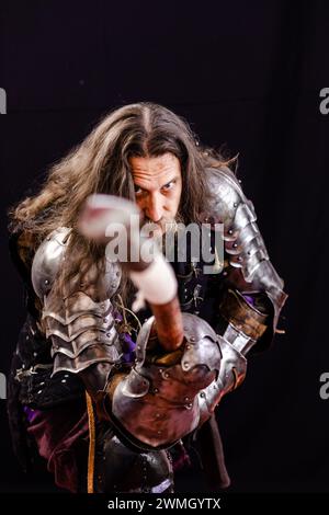 Performance pour touristes. Composition verticale. Portrait d'un homme charismatique habillé en chevalier médiéval avec une lance lors d'un reconstitutionnisme historique Banque D'Images