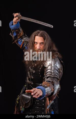 Composition verticale. Composition verticale. Portrait d'un homme charismatique habillé en chevalier médiéval avec une épée lors d'une reconstitution historique. P Banque D'Images