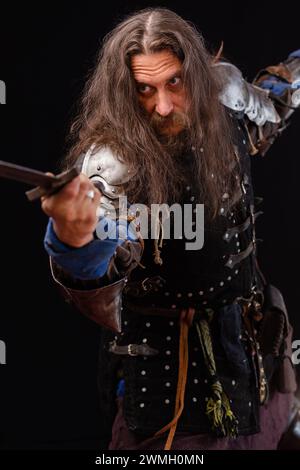 Composition verticale. Performance pour touristes. Composition verticale. Portrait d'un homme charismatique habillé comme un chevalier médiéval avec une épée pendant un Banque D'Images